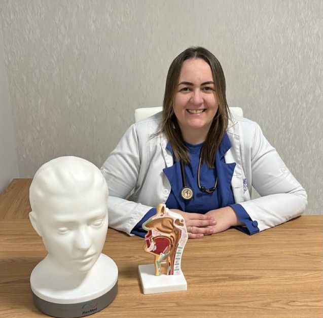 Andressa Schmidt, fisioterapeuta do sono, com máscara de CPAP e modelo da via aérea